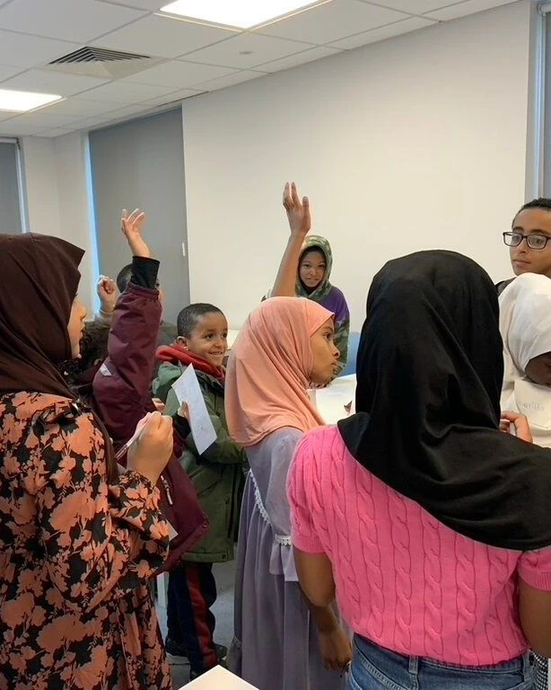 Pupils with their hands up during a lesson