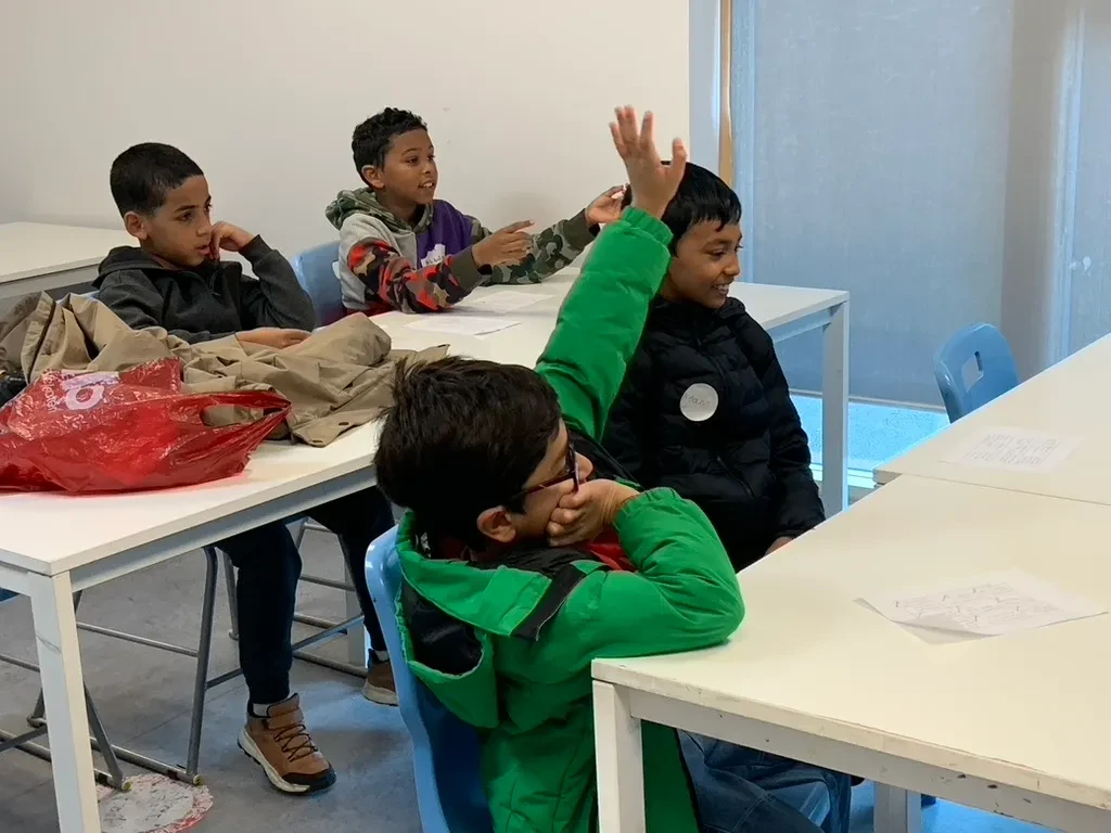 Pupils putting their hands up in a Forerunners classroom