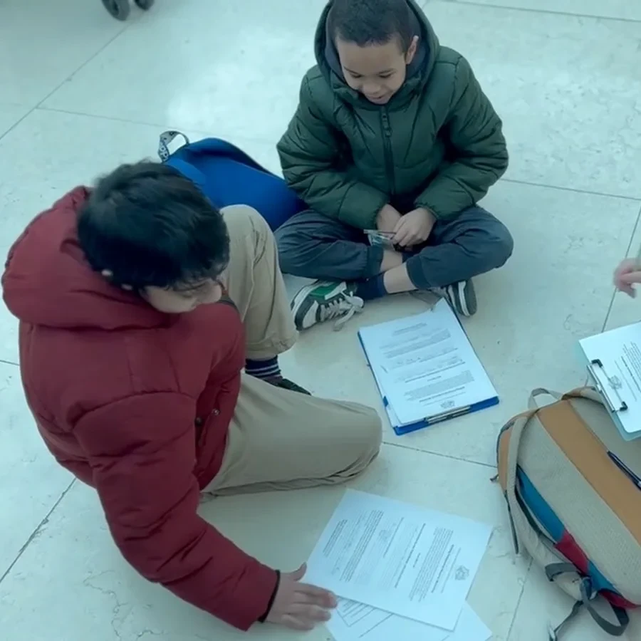 Primary students working through a task together on the floor